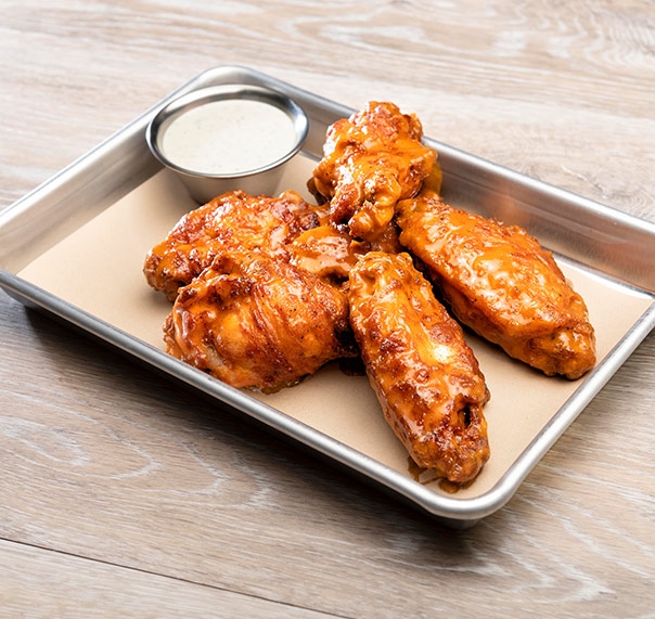 Tray of buffalo wings dressed with blue cheese sauce