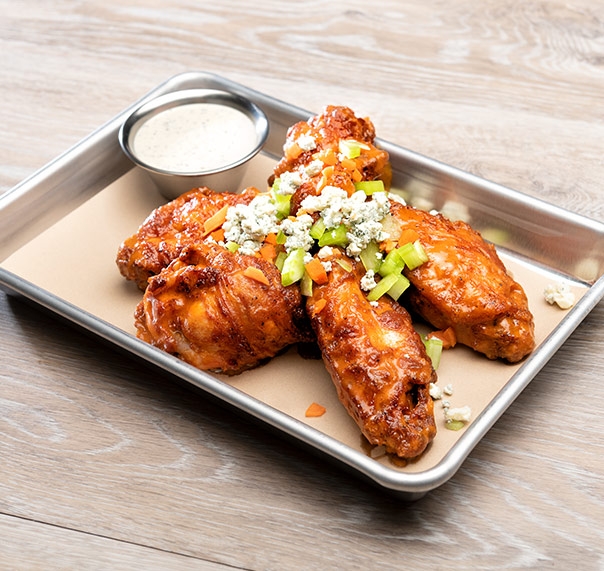 Tray of buffalo wings dressed with blue cheese sauce