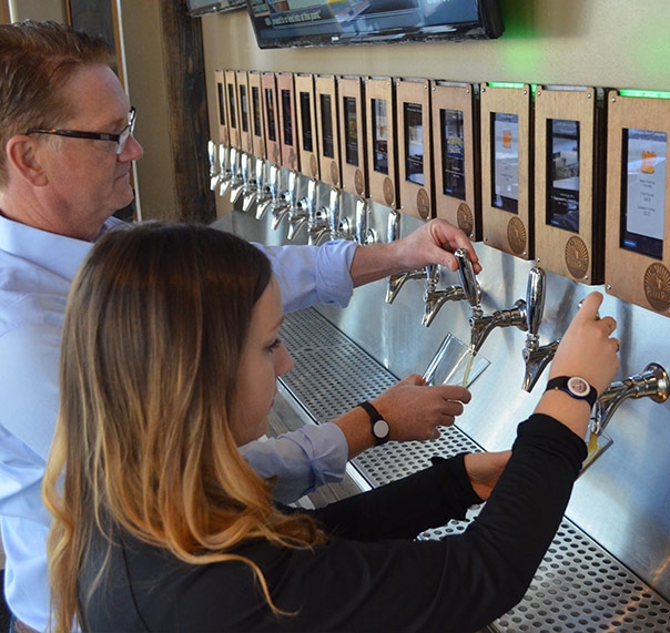 Employees training on the new ipourit self-serve beer stations at WOW American Eats